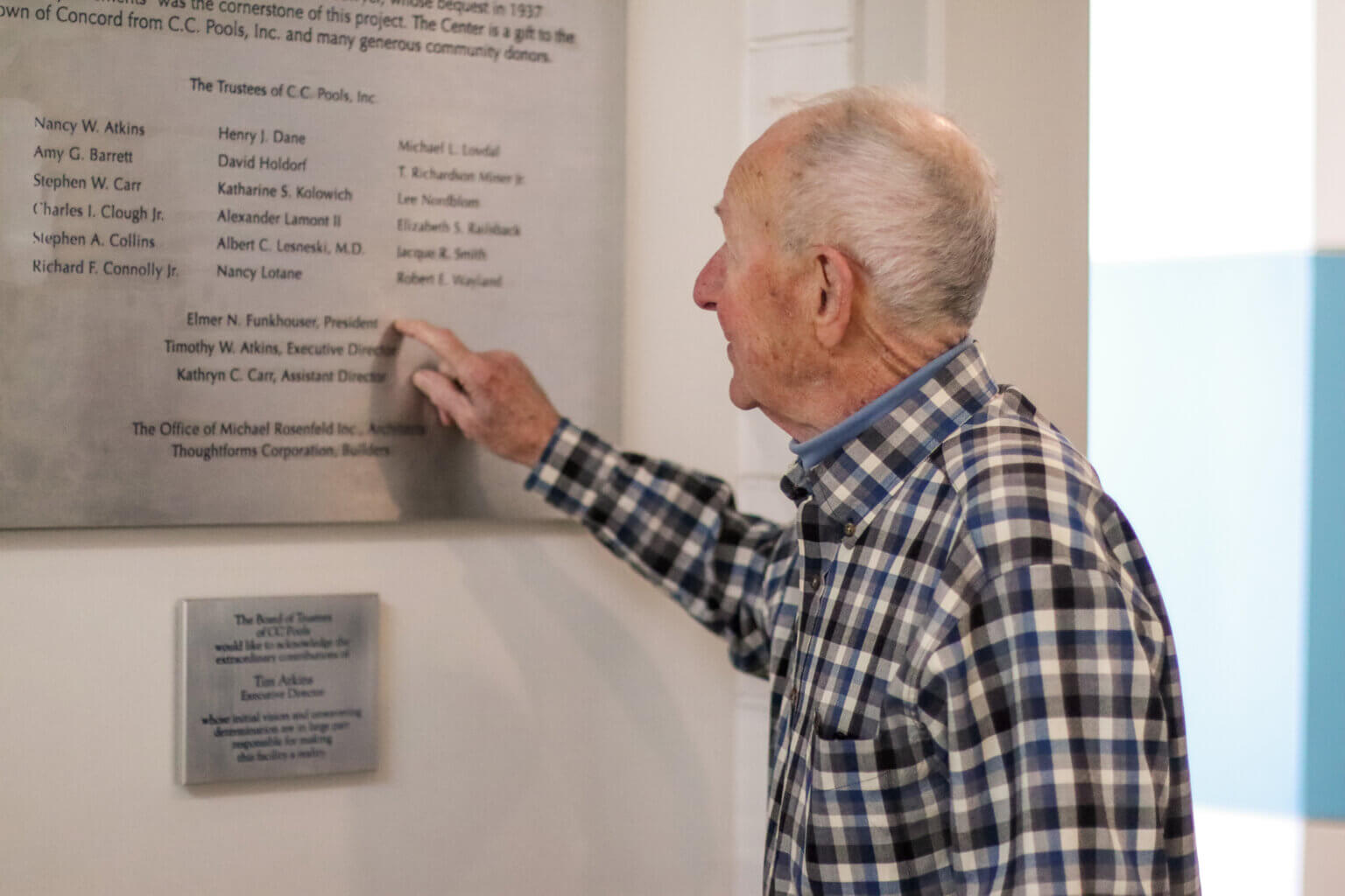Pete Funkhouser points to his name on a plaque at the Beede Center